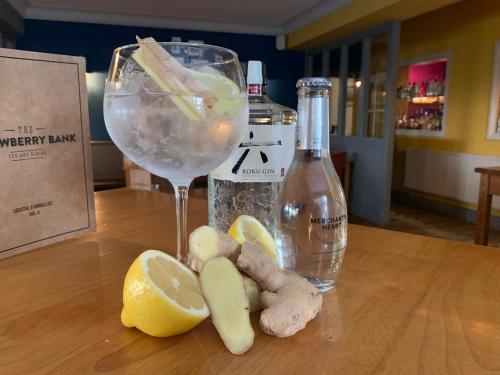 a glass of wine and lemon slices on a wooden table at Strawberry Bank Hotel, NEC in Meriden