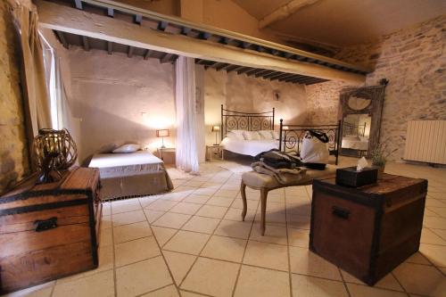 une chambre avec deux lits et une table dans une pièce dans l'établissement Le Mas du Père Jean, à Roche-Saint-Secret