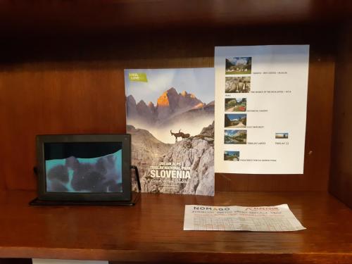 a television sitting on a table next to a menu at Apartment Zorc in Trenta