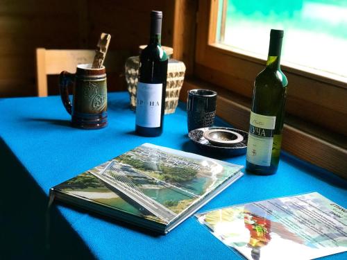a table with two bottles of wine and a book at Wooden Village Resort in Ponari