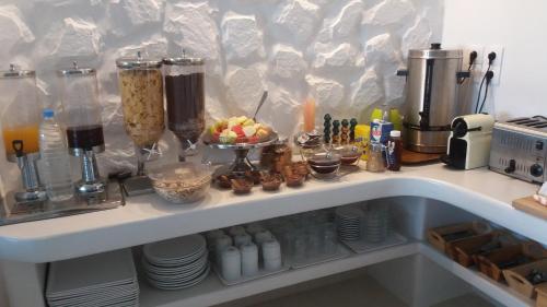 a kitchen counter with a shelf with food on it at Ioanna Apartments in Agios Prokopios