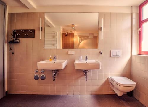 a bathroom with two sinks and a toilet at Villa Richter in Kurort Rathen