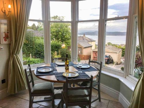 Un comedor con una mesa y un gran ventanal. en East Bank Apartment, en Grange-over-Sands