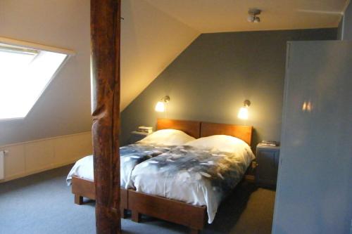 um quarto com uma cama grande num sótão em Bij ons op 20 em Nijeveen