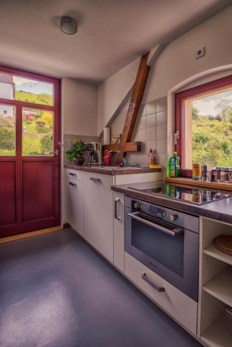 a kitchen with a stove top oven next to a window at Villa Richter in Kurort Rathen