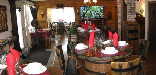 a dining room with wooden tables and chairs with red candles at Gîte Aux Traditions in Saint-Jean-des Piles