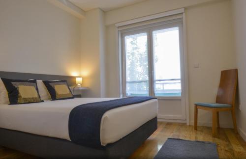 波多的住宿－休達斑點公寓，一间卧室设有一张大床和一个窗户。