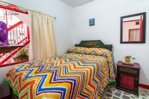 a bedroom with a bed with a colorful blanket at Hotel La Casona in Jardin