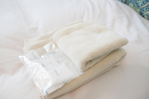 a pile of towels sitting on a bed at Kyo-Anthu Inn in Kyoto