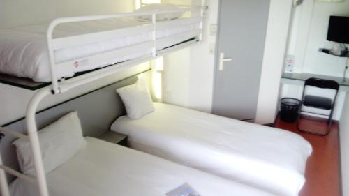 a hospital room with two beds and a bunk bed at Premiere Classe Périgueux - Boulazac in Boulazac