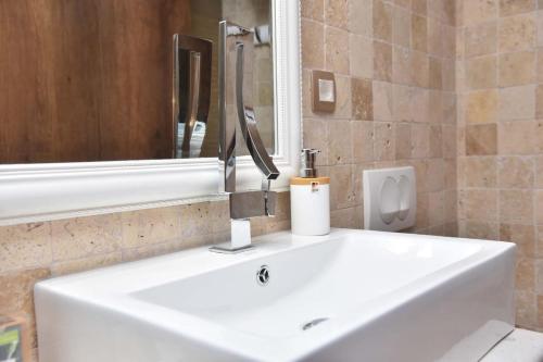 a bathroom with a white sink and a mirror at Old Town Skyline apartment 3 in Budva