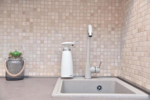a kitchen sink with a soap dispenser on a wall at Old Town Skyline apartment 3 in Budva