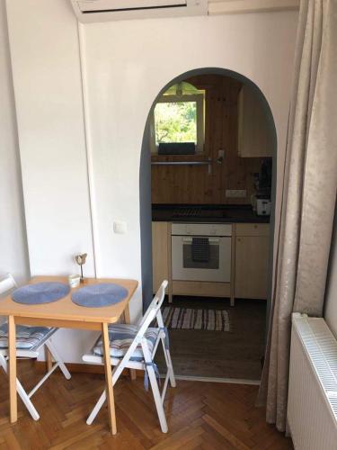 stół i krzesła w kuchni z łukiem w obiekcie Studio Mulej w Bledzie