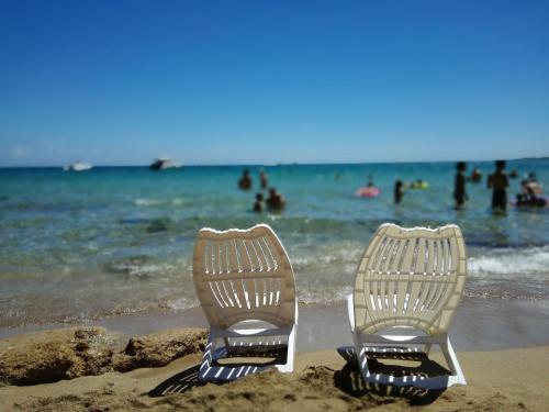 two chairs sitting in the sand on a beach at Villa Carmela Arenella in Arenella