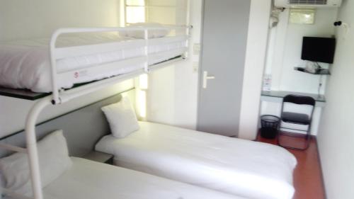 a hospital room with a bunk bed and a desk at Premiere Classe Périgueux - Boulazac in Boulazac