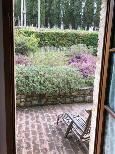 a wooden bench sitting in front of a window at Residenzia Del Sogno in Castellina in Chianti