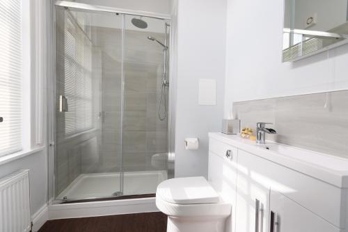 a white bathroom with a shower and a toilet at The Mortimer Arms in Romsey