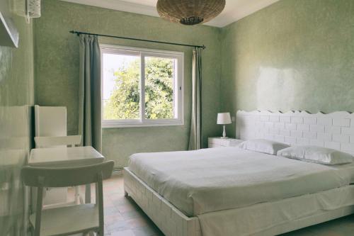 Un dormitorio con una cama grande y una ventana en Blue Kaouki en Sidi Kaouki