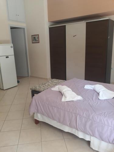 a bedroom with a purple bed with two white pillows at Cozy apartment in the center of Aighion Achaia - ground floor - ισόγειο στουντιο in Aigio