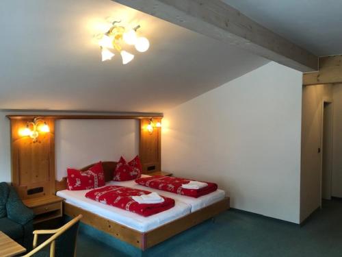 a bedroom with a bed with red pillows and a ceiling fan at Norishütte in Mittelberg