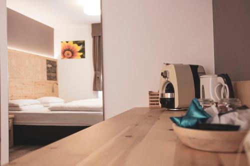 a kitchen counter with a coffee maker and a bed at DolceVita Ambiez B&B in San Lorenzo in Banale