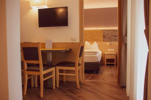 a small room with a table and chairs and a bed at DolceVita Ambiez B&B in San Lorenzo in Banale
