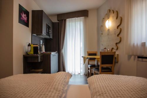 a room with two beds and a table and a window at DolceVita Ambiez B&B in San Lorenzo in Banale