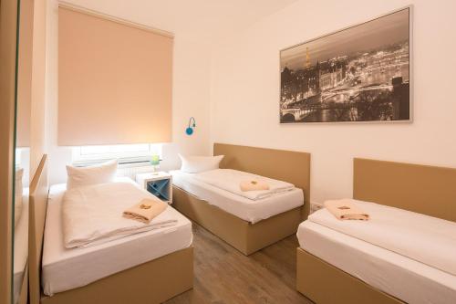 um quarto com duas camas e uma foto na parede em T3 Cityloft Appartments em Mönchengladbach