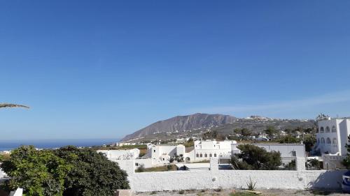 uma vista para uma cidade com edifícios brancos e o oceano em Maistrali Prive em Karterados