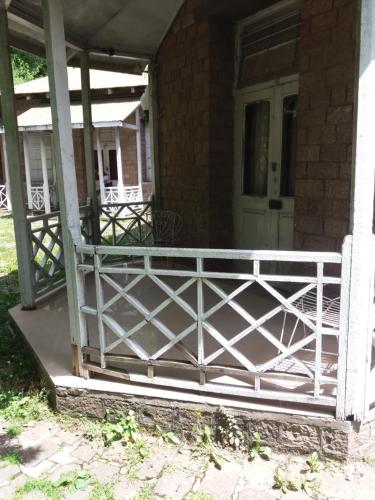 a front porch with a white fence on a house at BRIGHTLANDS HOTEL in Murree