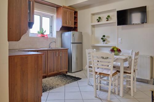 een keuken met een tafel en stoelen en een koelkast bij Alexis's House in Pylos