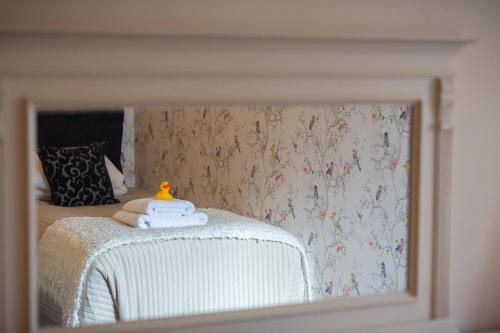 a reflection of a bedroom with a bed in a mirror at Chester House Hotel in Bourton on the Water