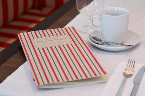 a book on a table with a cup of coffee at The Harmonie Vienna, BW Premier Collection in Vienna