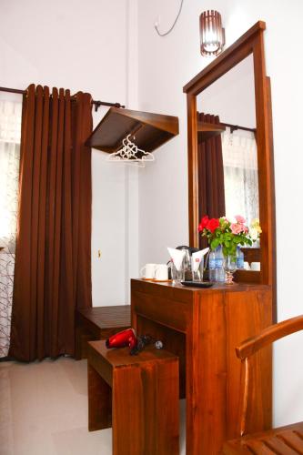 a bathroom with a mirror and a table with flowers at Brisa Marina in Negombo