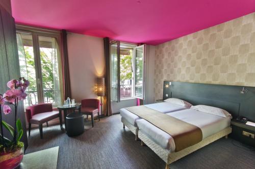 ein Schlafzimmer mit einem großen Bett und einer rosa Decke in der Unterkunft Aéro in Paris