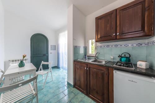 a kitchen with wooden cabinets and a sink and a stove at Ischia Dream Sunset in Ischia