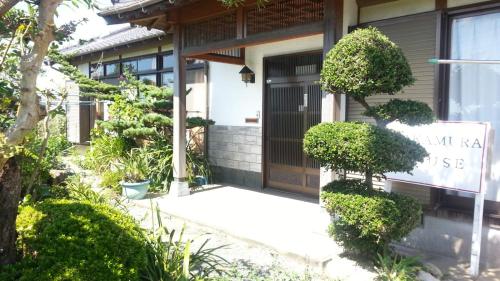 a house with a sign on the front door at Guest House Nakamura House in Oki