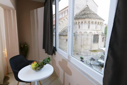 a bowl of fruit sitting on a table in front of a window at Zoilo Rooms self check-in in Zadar