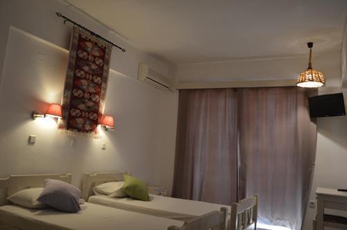 a bedroom with two twin beds and a window at Kostas Studios in Faliraki
