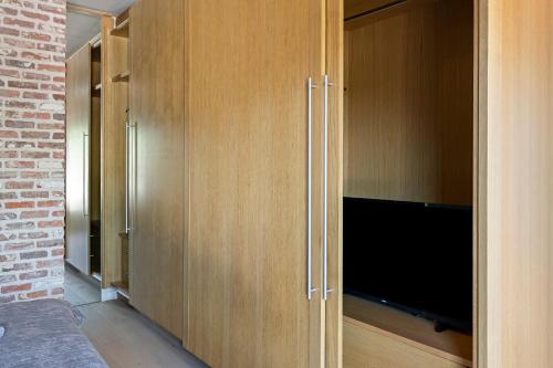 a large wooden cabinet with a television in it at René in Lichtervelde