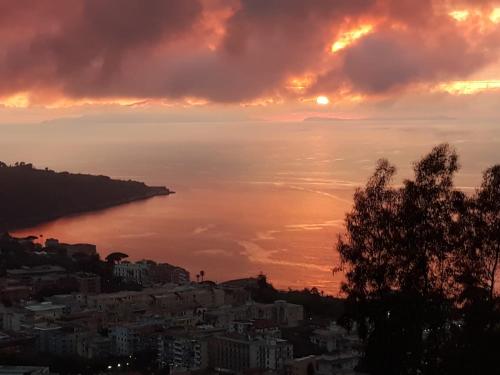 a sunset over the water with a city at Le Muse Suite in Sorrento