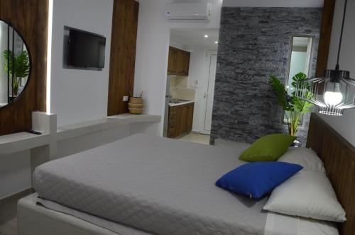 a bedroom with a large bed with blue pillows at Kostas Studios in Faliraki