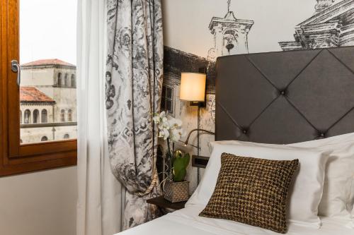 a bedroom with a white bed with a black headboard at Venice Maggior Consiglio in Venice