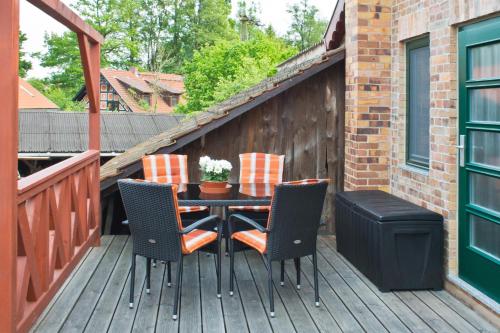 a patio with a table and chairs on a deck at Lehdsche Heubuchten in Lehde