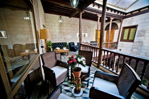 a balcony with chairs and a table with flowers on it at Hotel Condes de Castilla in Segovia