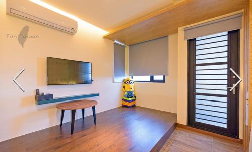 a living room with a table and a tv at 澎湖寶貝民宿 in Huxi