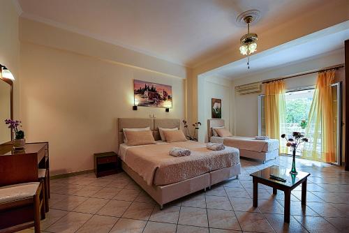 a bedroom with a bed and a living room at Angelica Hotel in Agios Gordios