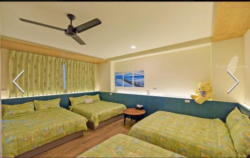 a bedroom with two beds and a ceiling fan at 澎湖寶貝民宿 in Huxi
