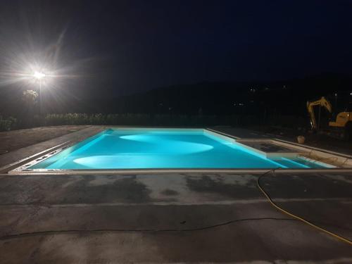 a blue swimming pool at night with a street light at Agriturismo Casa Rosa in Lucca