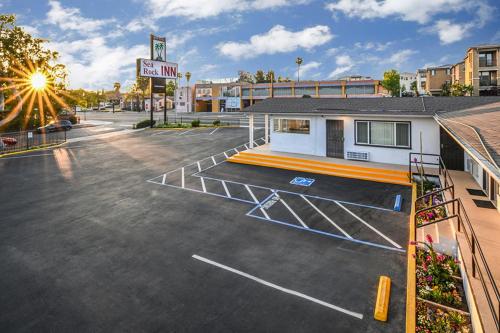 a basketball court in a parking lot in front of a building at Sea Rock Inn - Long Beach in Long Beach